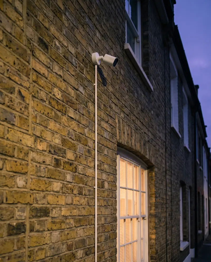 A CCTV camera on a London brick terrace at dusk